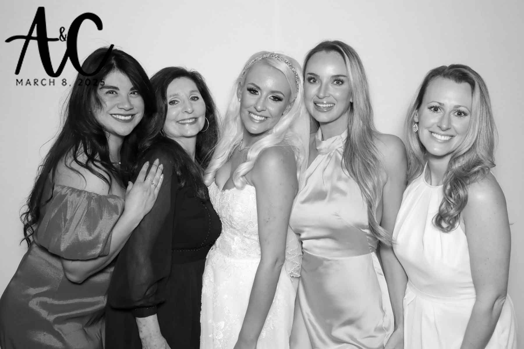 Four guests pose with the bride in the photo booth