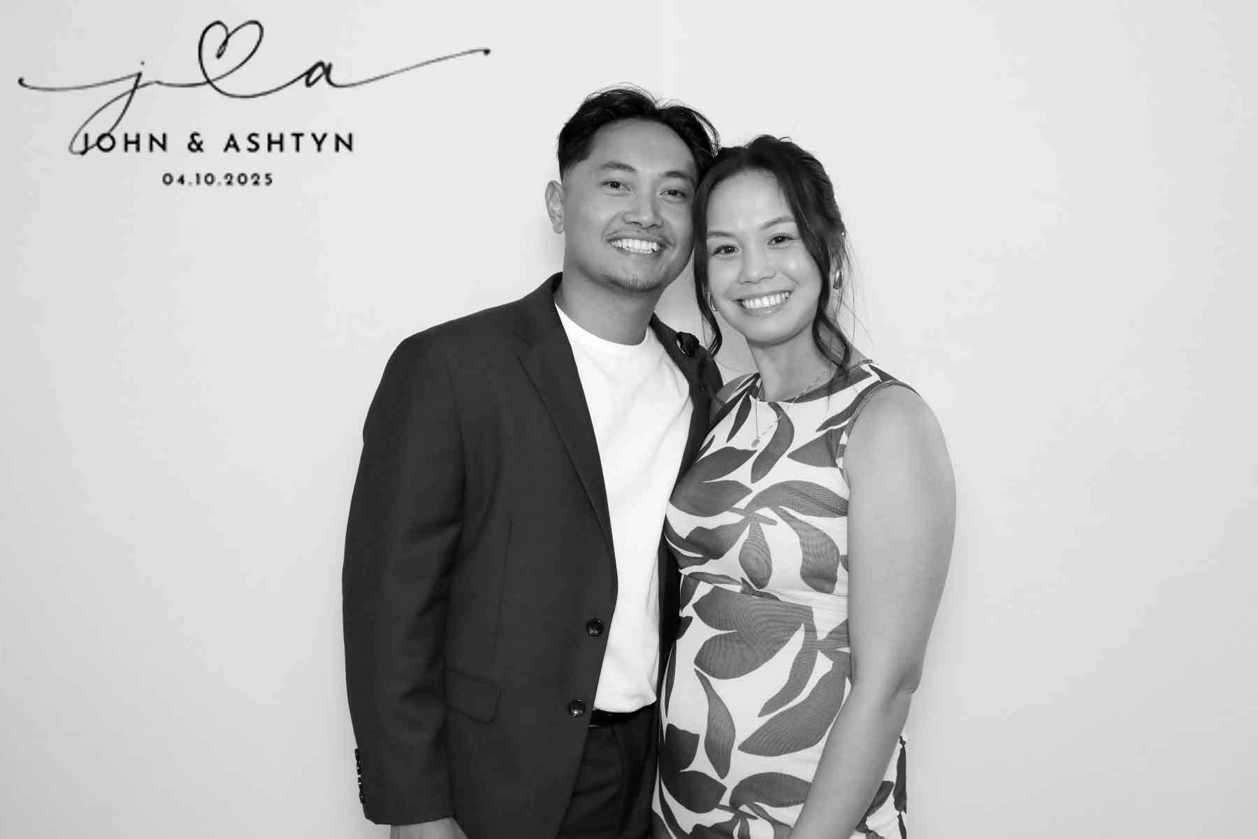 A couple pose against a white backdrop